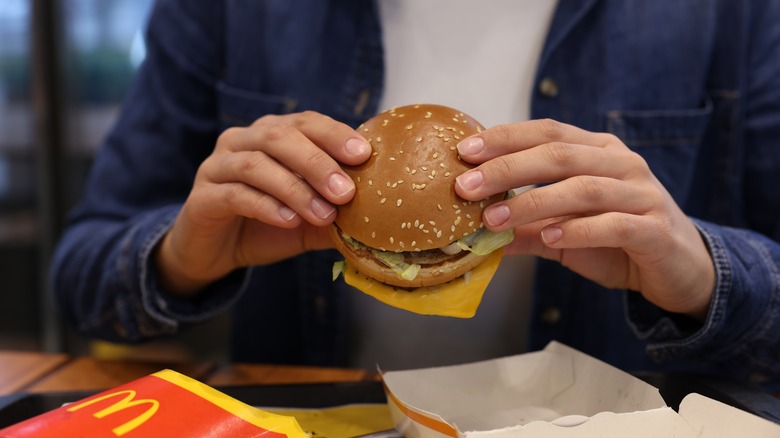 person eating McDonald's hamburger