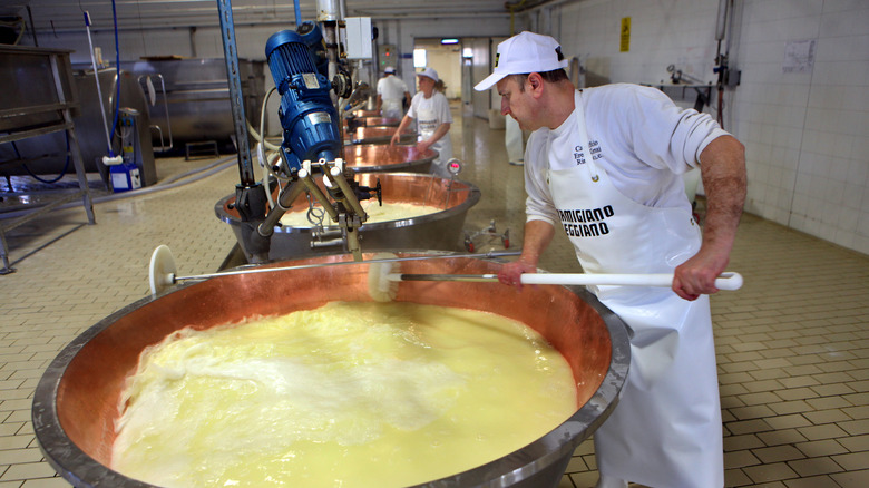 Cheesemaker stirring copper pot