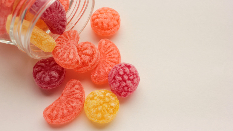 Hard fruit candy spilling from jar