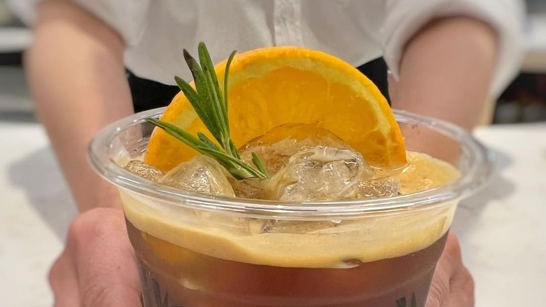 Woman holding a cup of sparkling coffee