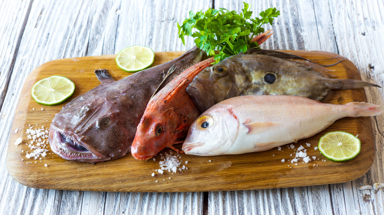 fresh monkfish among other fish on a board