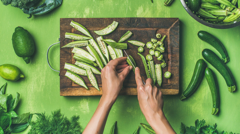 hands cutting okra pods lengthwise