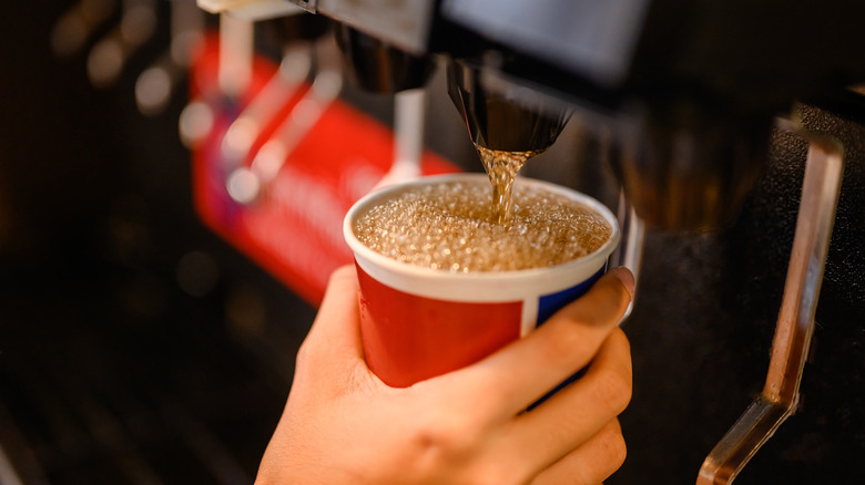 someone pours drink from machine