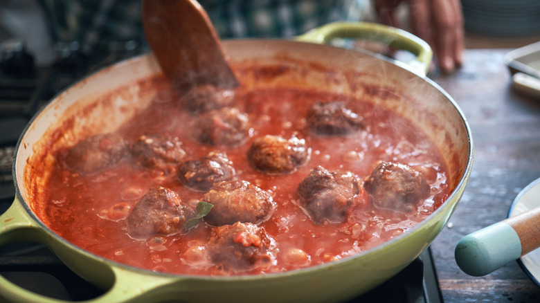 Meatballs simmering in red sauce