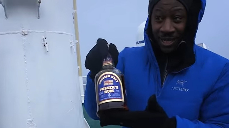 Burrell holding rum in Antarctica