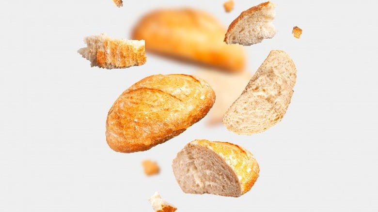 Wheat bread loaves flying on white background 