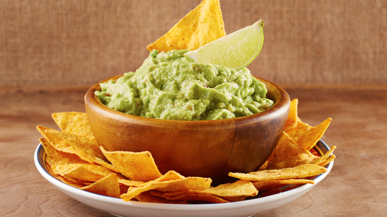 Tortilla chips in bowl of guacamole