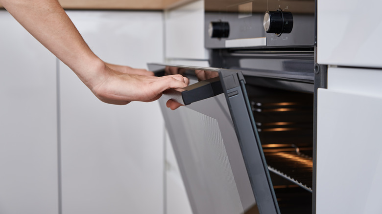 Hands opening oven door