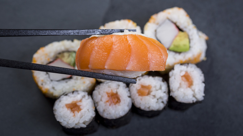 A sushi chef rolls a maki roll