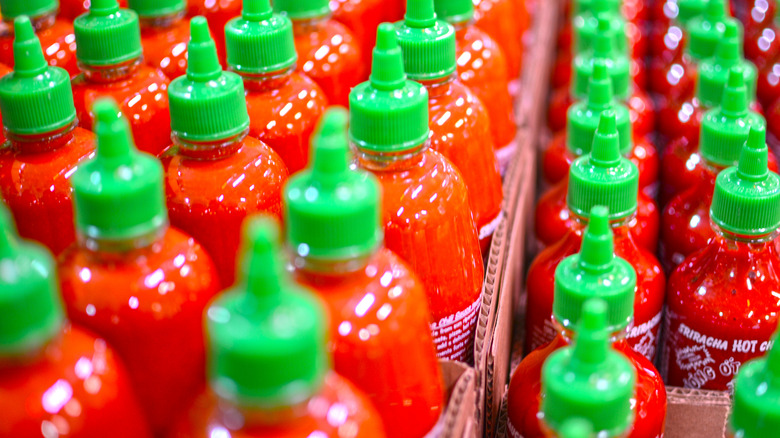 lone bottle of sriracha on shelf