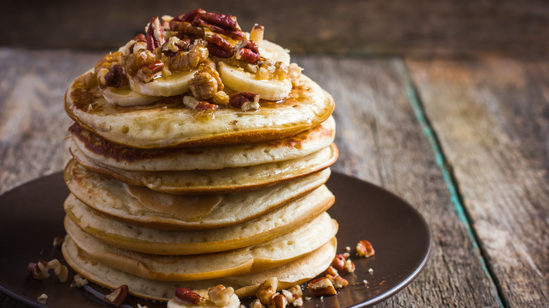 stack of pancakes with bananas and nuts