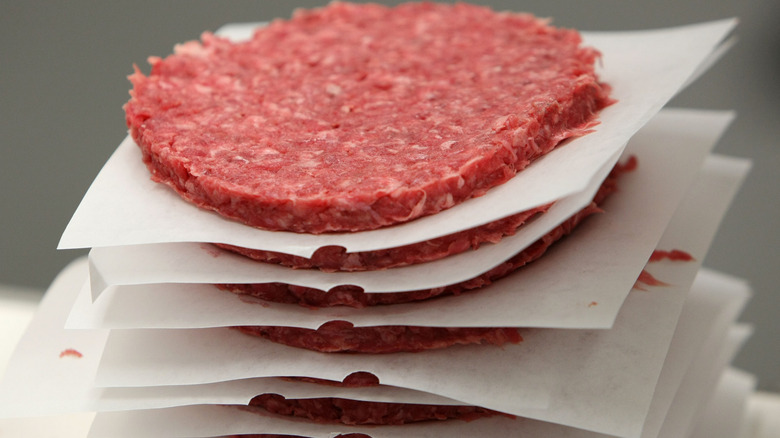 stack of factory-formed ground beef patties separated by parchment paper