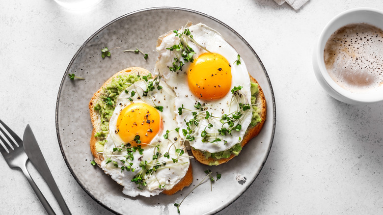 breakfast plate of avocado toast with fried eggs