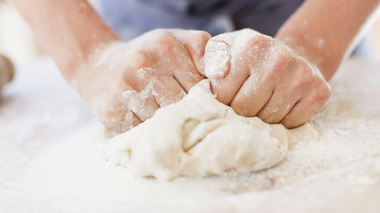 Hands kneading bread dough