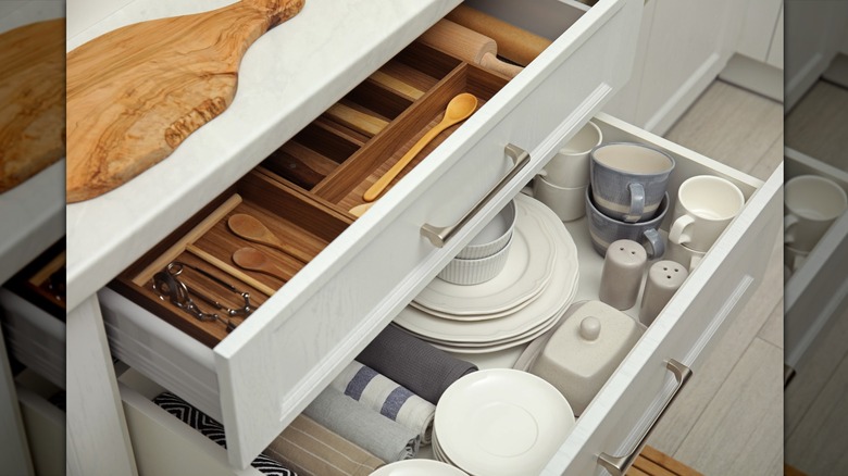 Well-organized drawers lay open in display in naturally designed kitchen.