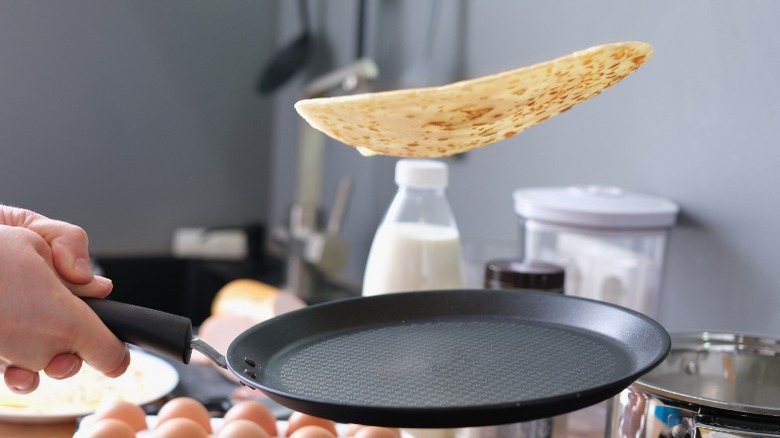 Flipping crêpe with a pan