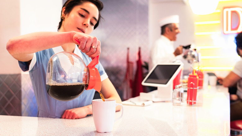 Waitress fills coffee cup