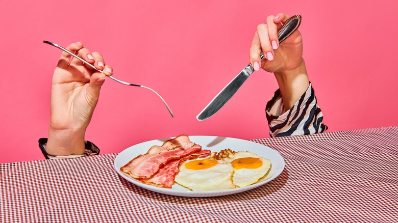 bacon and eggs on pink background