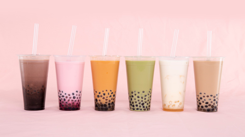 colorful row of boba teas on pink backdrop