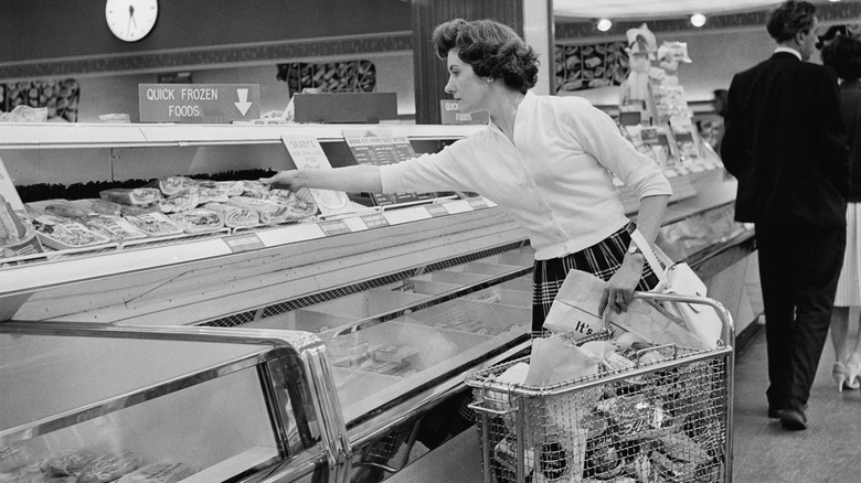 Black and white photo of woman shopping for frozen foods