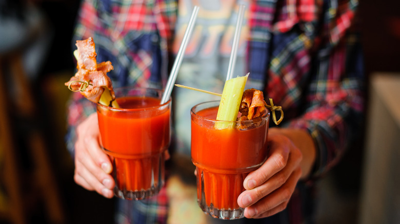 Person carrying Bloody Mary cups