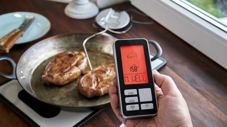 Person checking temperature of pork