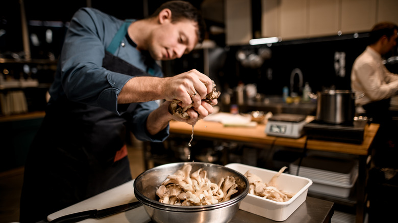 Chef draining oyster mushrooms