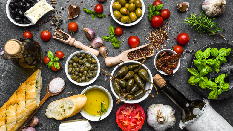 Olives, capers, herbs, and other ingredients on a table