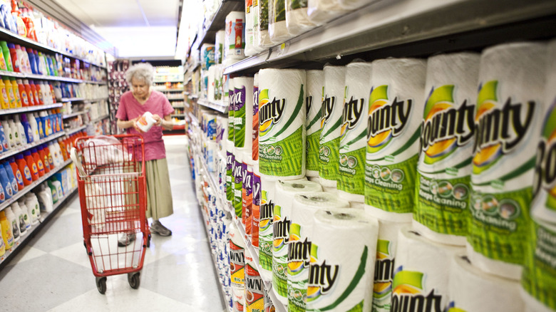 A shopper selects paper products at a grocery store