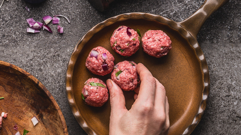 Person forming meatballs on plate