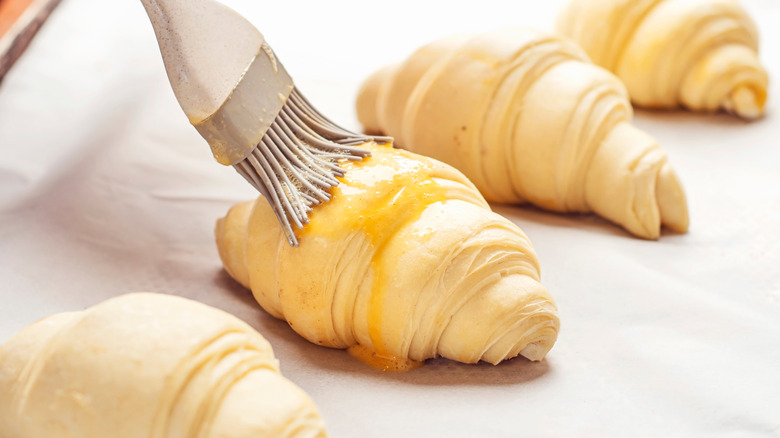 Brushing egg wash on croissants