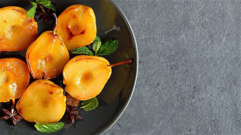 Halved poached pears on dusky plate 