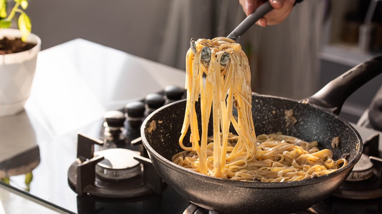 Person making creamy pasta. 