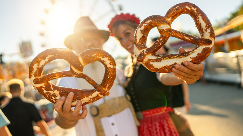 People holding german pretzels