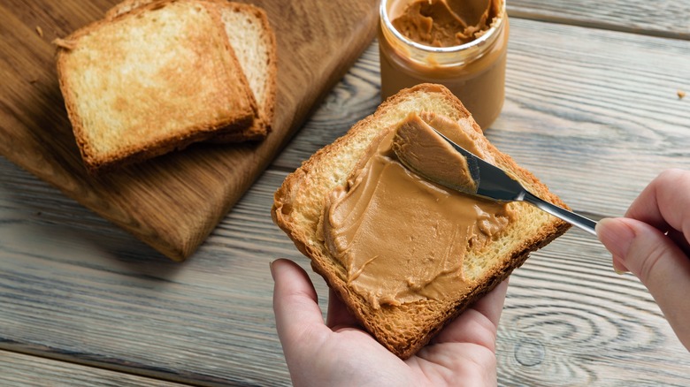 spreading peanut butter on toast