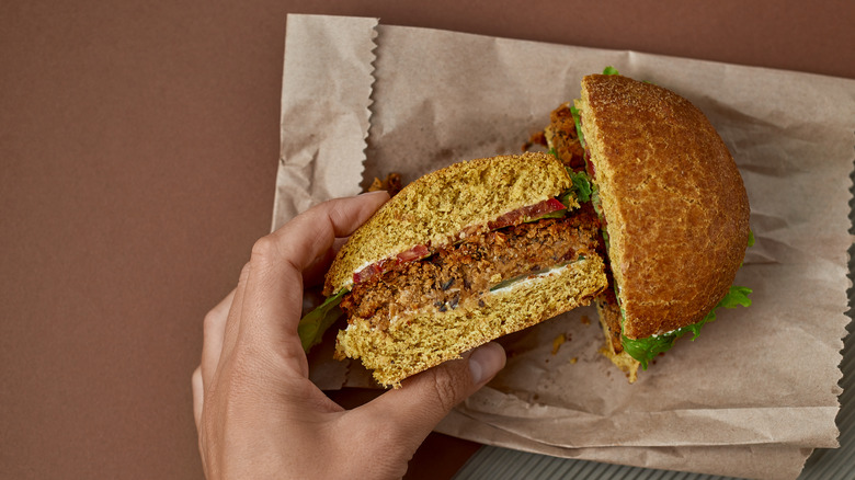 Hand holding a veggie burger