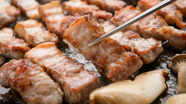 flipping meat with chopsticks