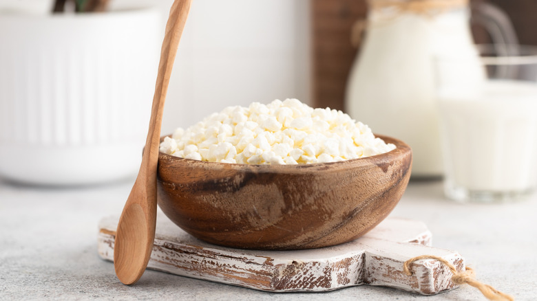 Cottage cheese in wooden bowl with a wooden spoon