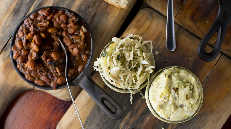 Beans, slaw, and potato salad on wooden serving boards