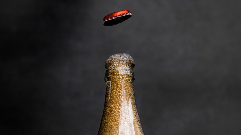 glass soda pop bottle with lid popping off