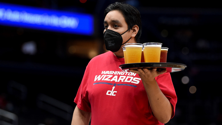 A server carries a tray of beers at an NBA game