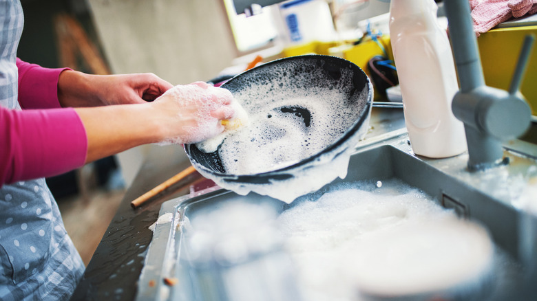 Person scrubbing a pan