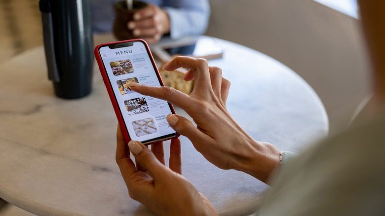 Woman pointing at phone menu