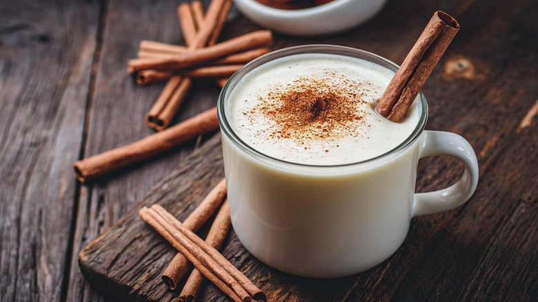 Eggnog in a mug with a cinnamon stick