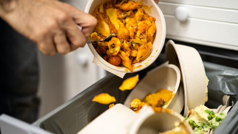 Discarding leftover food into garbage bin