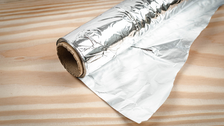 roll of aluminum foil on wooden table