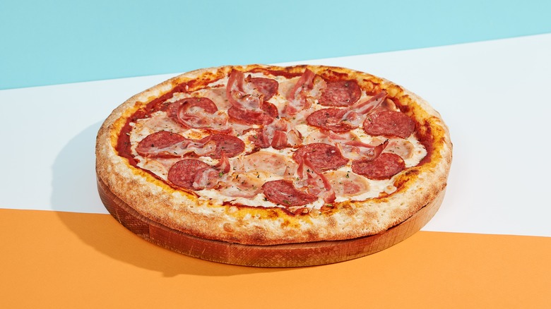 Pepperoni and ham pizza with colorful background