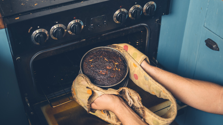 removing burnt cake from oven