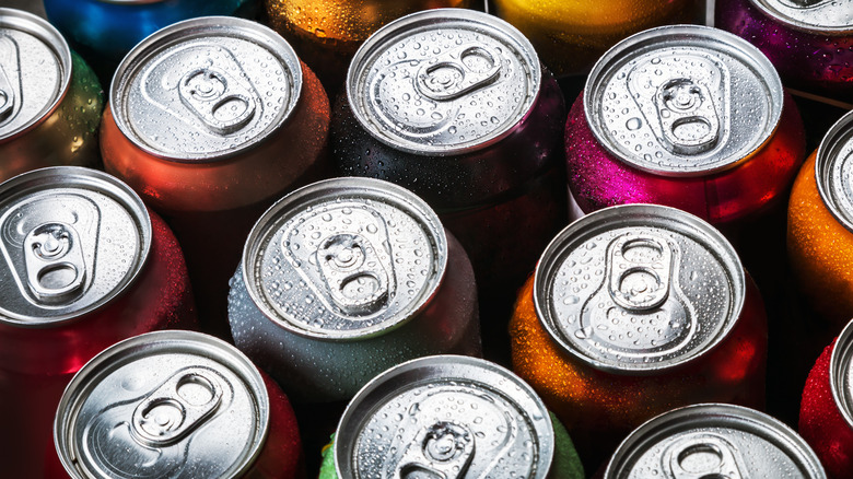 tops of soda cans with mist