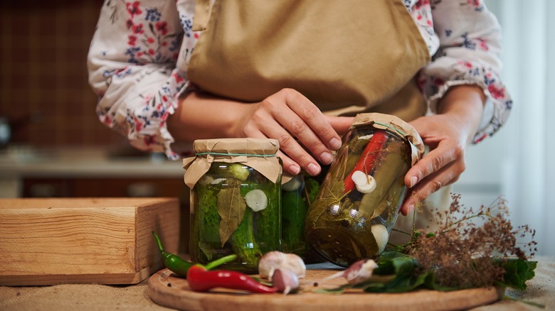 A set of hands canning pickled vegetables